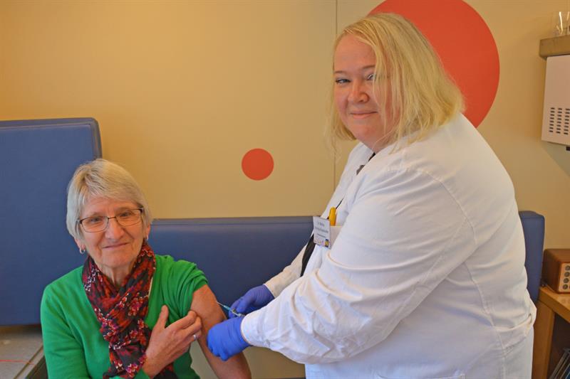 Eine Ärztin setzt einer Besucherin eine Masern-Impfung